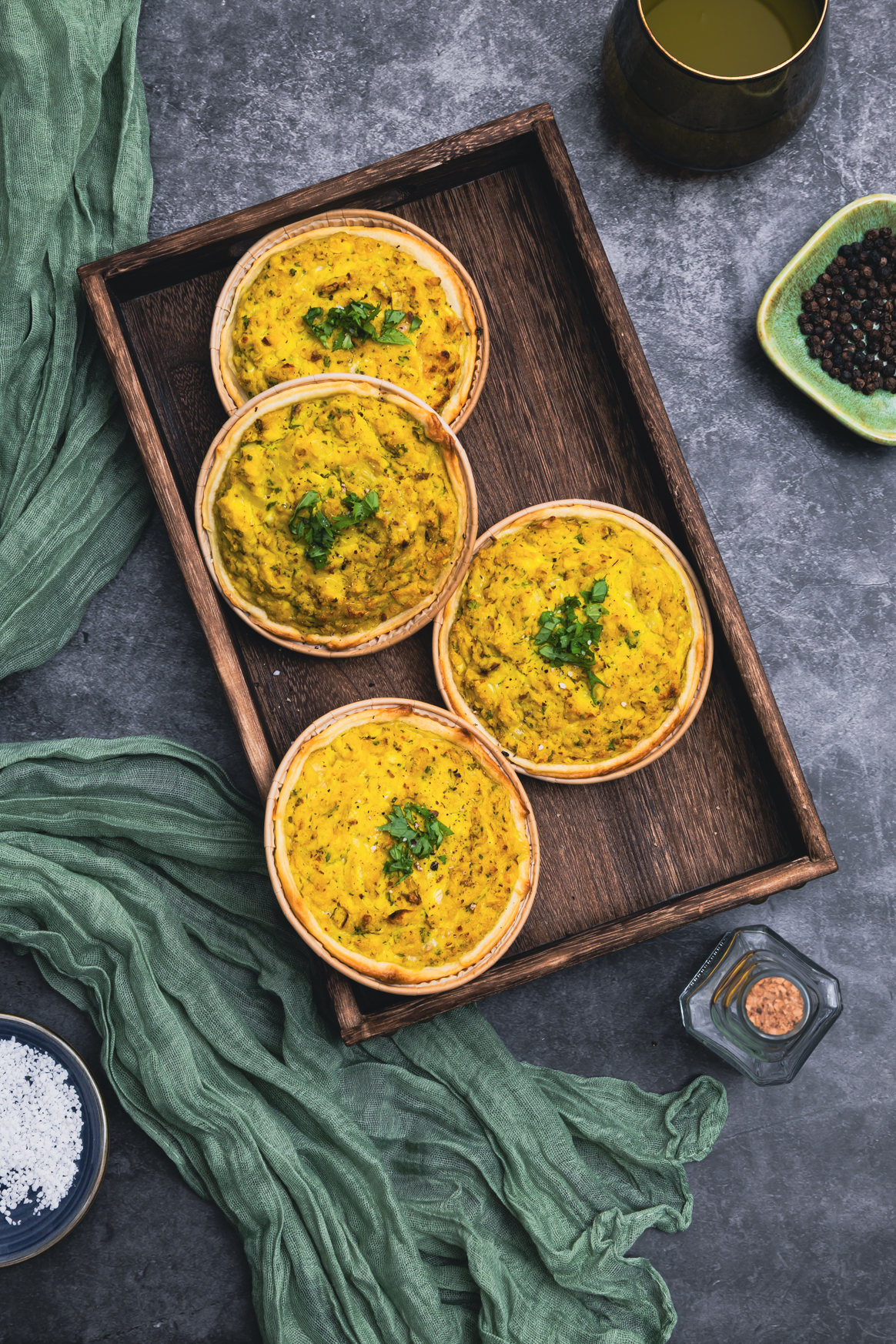 Vegane Mini-Quiches auf Holzbrett im Topshot fotografiert