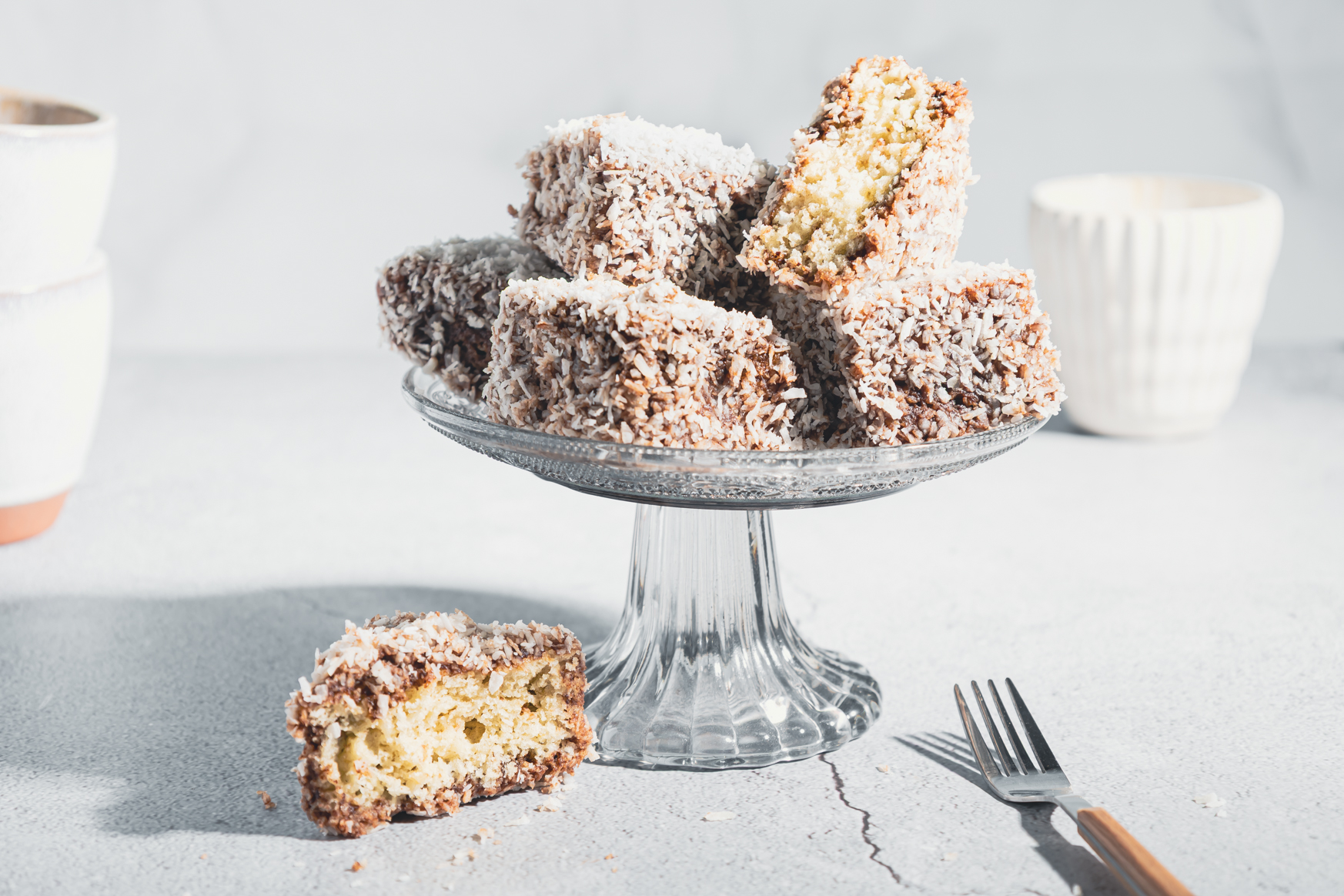 Schoko-Kokos-Würfel auf einer Etagere auf hellem Untergrund fotografiert