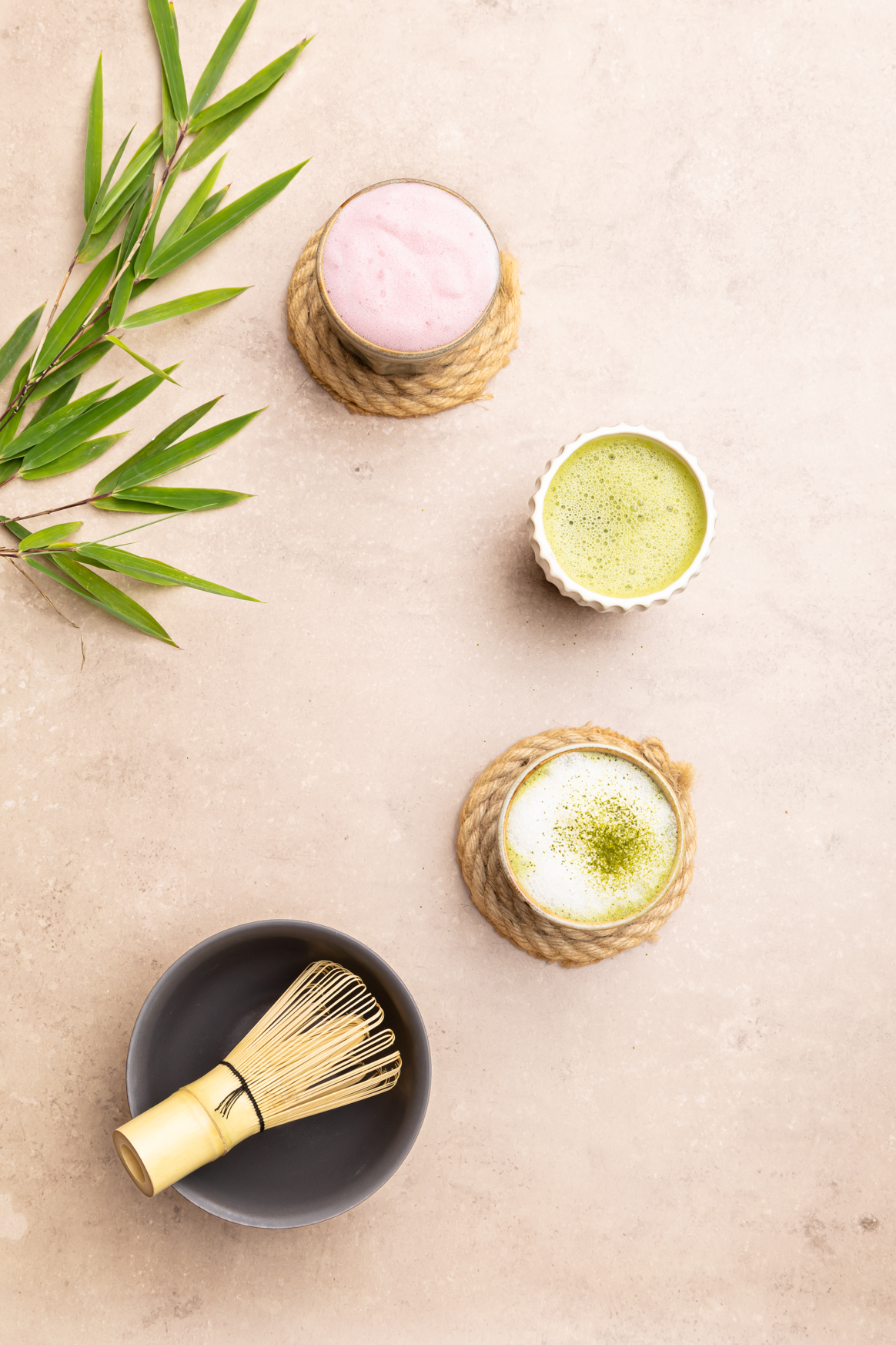 Matcha-Tee verschiedene Tassen auf beigem Untergrund mit Bambus